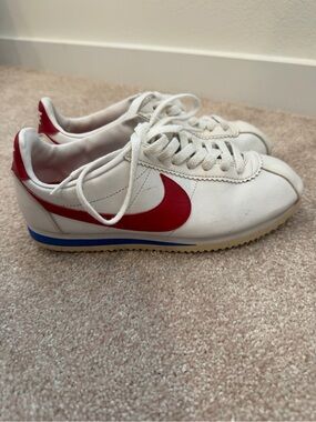 Nike White Leather Sneakers with Red Swoosh and Blue Sole Accent